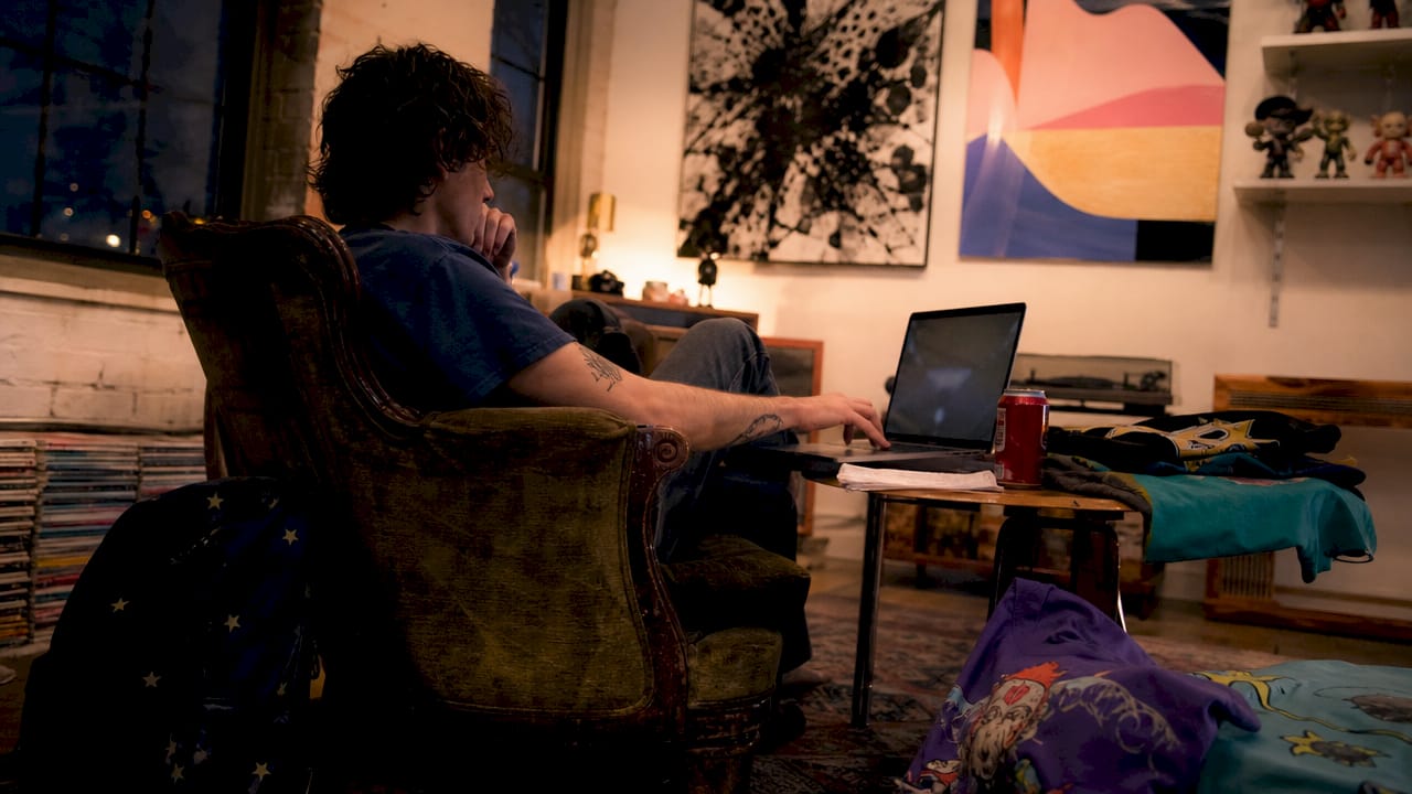 Person browsing graphic apparel online in bedroom