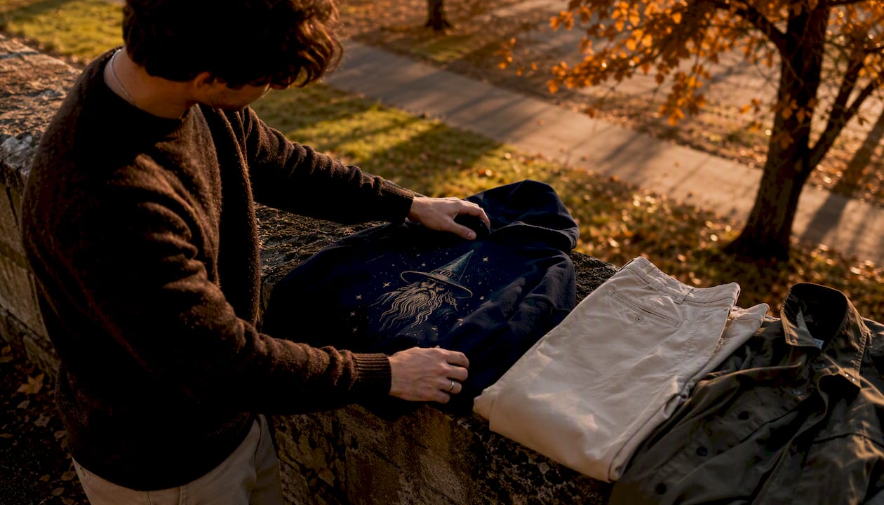 Hands assembling themed outfit pieces outdoors