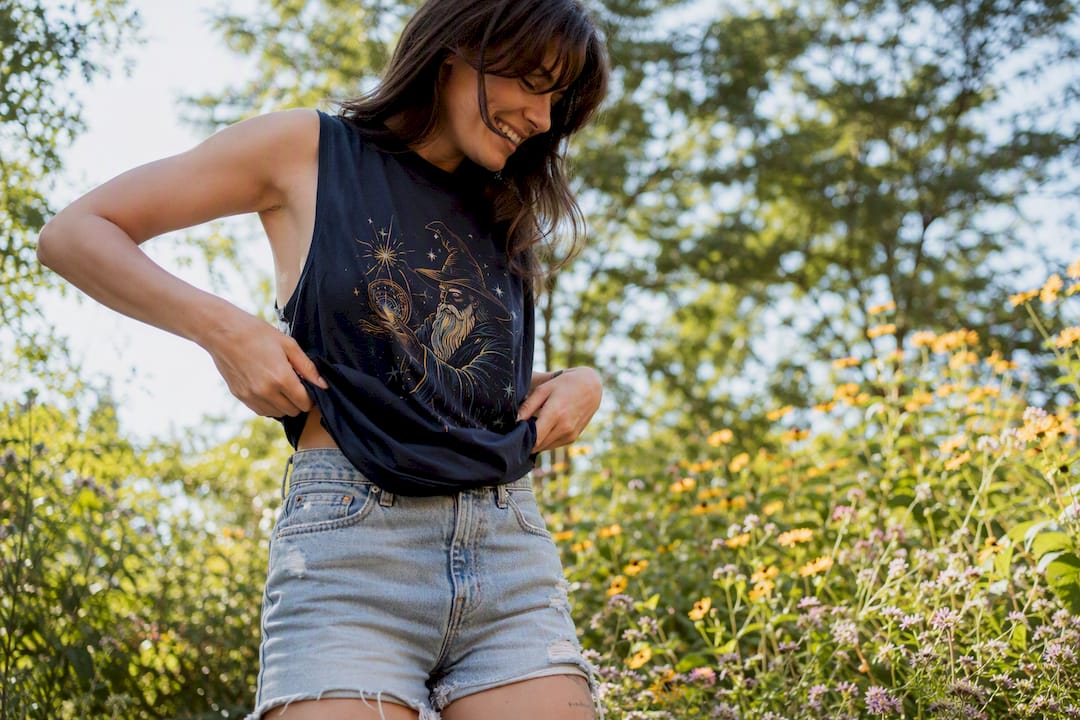 Person adjusting playful tank top outdoors