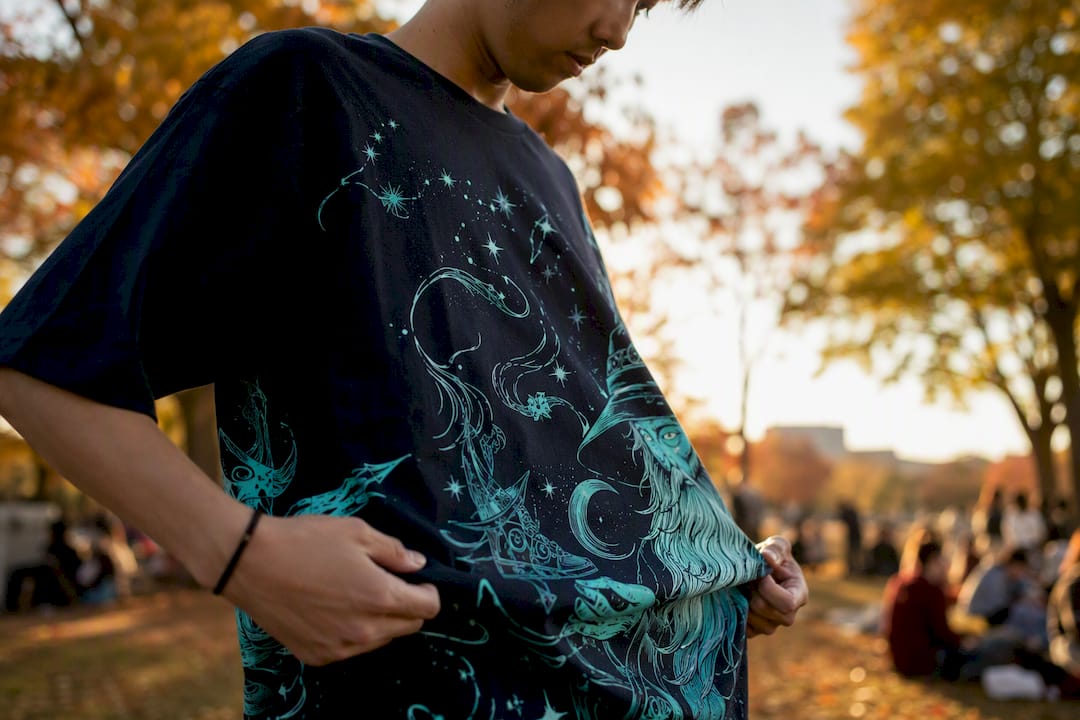 Person adjusting playful graphic tee outdoors